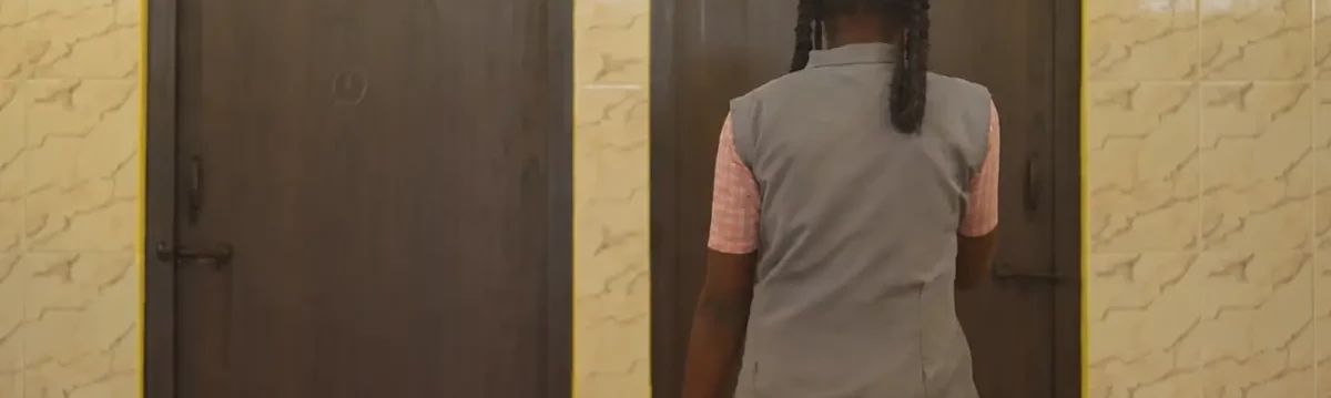 Girl standing outside a clean school washroom supporting WASH initiatives