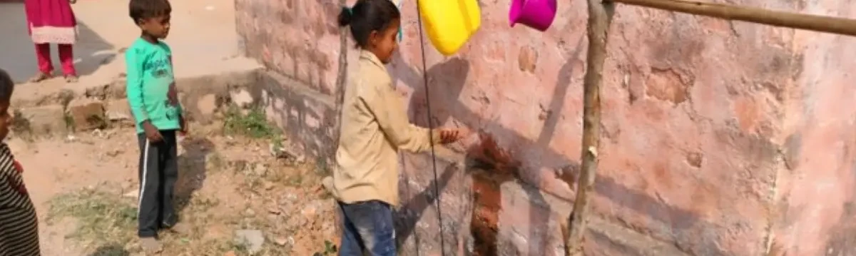 Children washing their hands at a handwashing station to promote hygiene